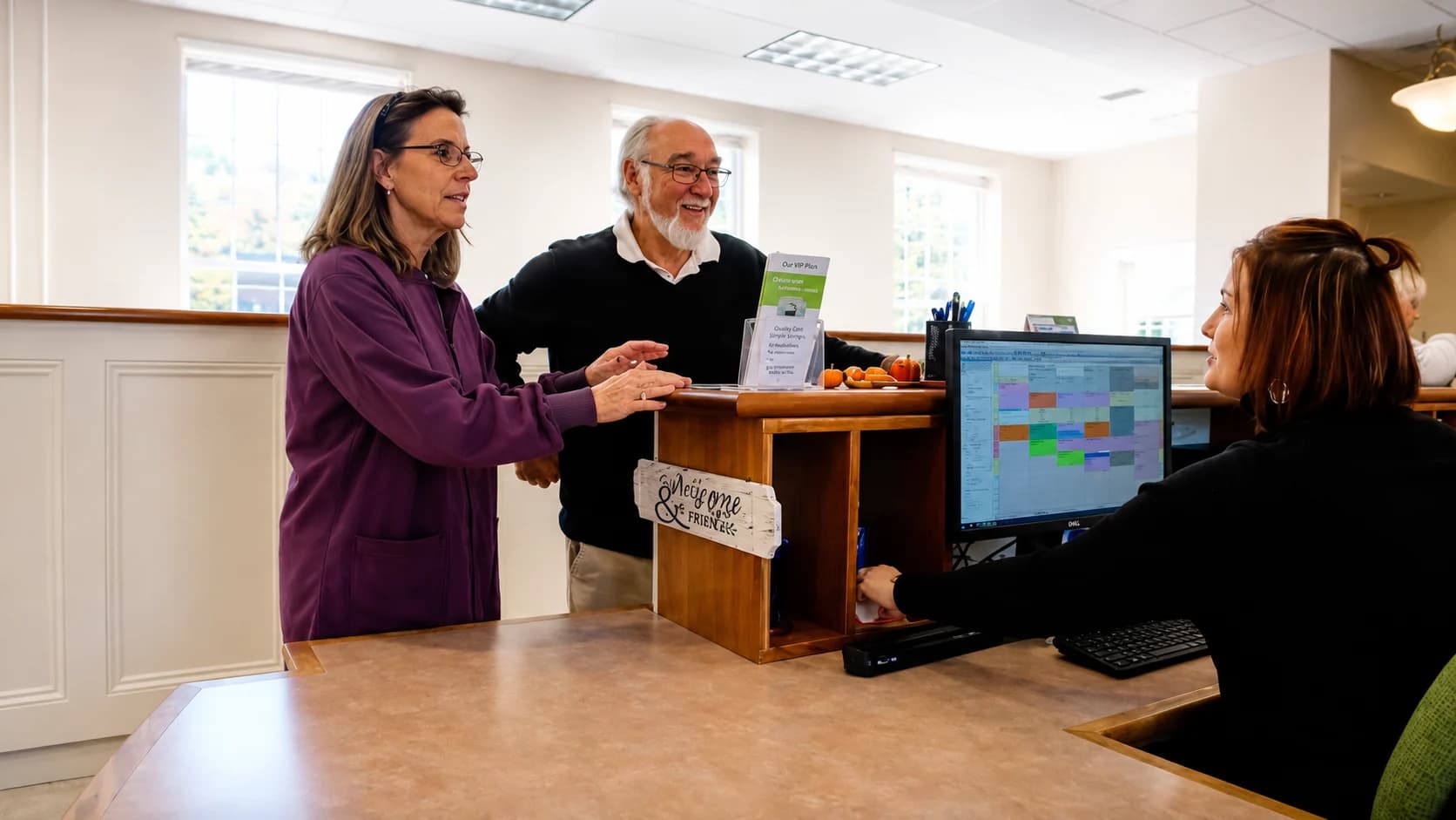 Two patients checking in with a team member at our front desk