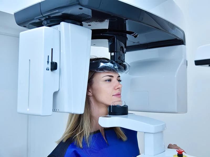 A patient reviewing their 3D scan and treatment plan with the dentist at a free implant consultation