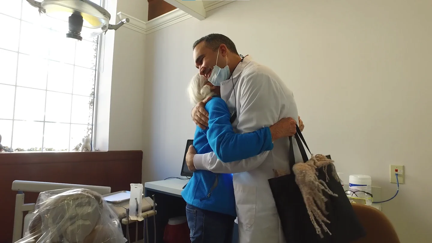 One of our dentists greeting a long-time patient with a hug