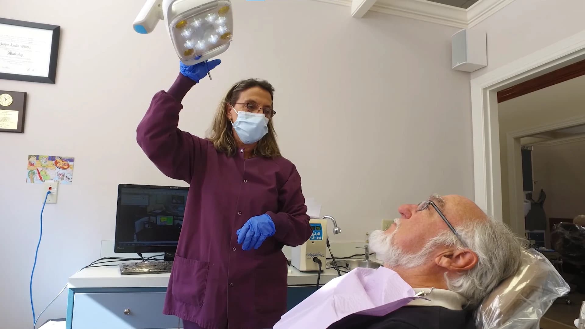 Clinician adjusting the overhead light above a calm, comfortable patient
