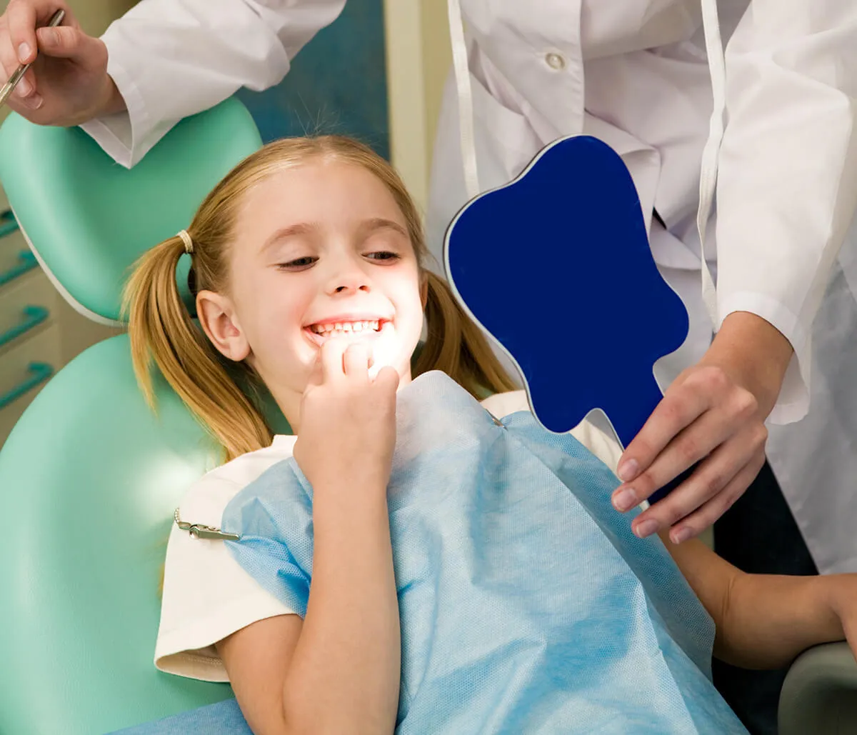 A dentist gently treating a young patient